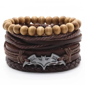 Détail d'un ensemble de bracelets multicouches en cuir avec perles et breloque batman