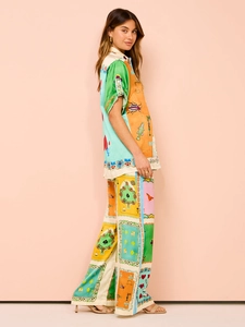 Detail of satin texture and unique print on long sleeve shirt and wide leg trousers