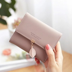 Close-up of pink PU leather wallet with leaf pendant and stitched logo detailing