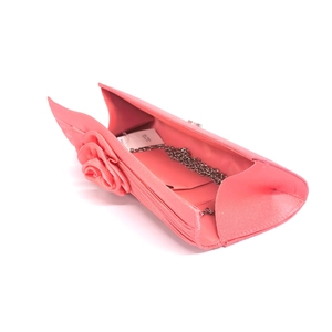 Detail of pink satin evening clutch featuring 3D rose and detachable silver chain strap