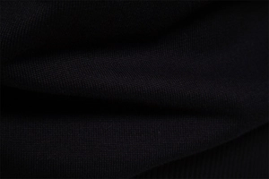 Macro shot showing the texture and knit pattern of the black cotton V-neck sweater