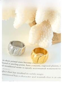 Detailansicht breit gewundener geometrischer Ringe in poliertem Gold- und Silberfinish