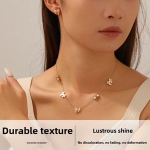 Detail of gold bow necklace and stud earrings set worn on a model for an elegant look