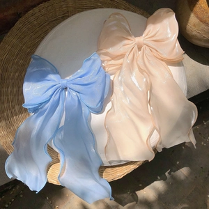 Elegant large mermaid blue and orange sheer tulle bow hair clips on a white display tray