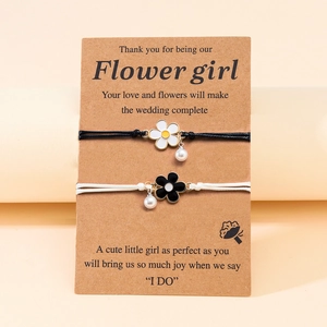 Floral pearl charm woven bracelets set on a Flower Girl wedding card, black and white ropes