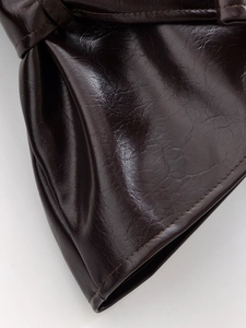 Close-up of deep brown leather jacket showing fine stitching and premium texture