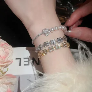 Elegant floral pearl bracelets set with zircon rose charms on a stylish magazine background
