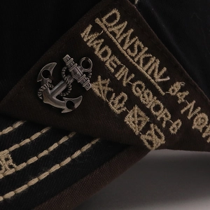 Detailed embroidery and vintage metal anchor accessory on the cotton baseball cap's side