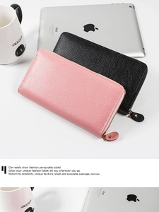 Detail of lychee textured leather wallets in pink and black with golden zippers