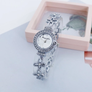 Detailed close-up of a silver quartz watch featuring a rhinestone bezel and clover band