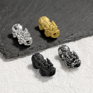 Macro detail of 18K gold plated Pixiu beads in silver, gold, black and charcoal finishes