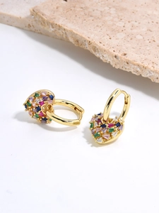 Macro view of gold-plated hoop earrings with colorful zircon pavé heart charms