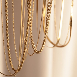 Close-up of gold-plated stainless steel chains including twist, Cuban, and snake link styles