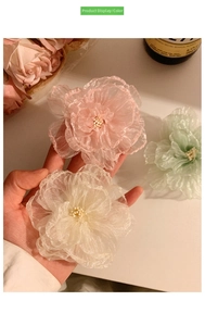 Detail of layered organza flower hair clips with pearl beads in pink white and green