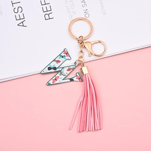 Close-up of pink tassel and letter W keychain with colorful butterfly pattern details