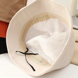 Close-up of beige bucket hat interior with adjustable strap and breathable lining