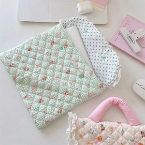 Close-up of quilted laptop sleeve featuring pink cartoon bunny and lace dot lining