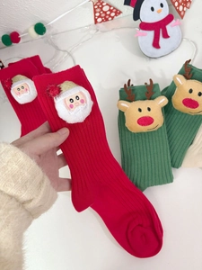 Detail of Christmas cotton socks featuring 3D Santa and reindeer plush figures