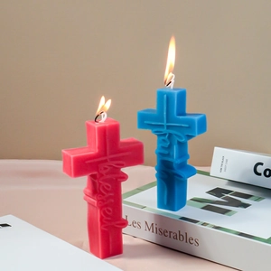 Detail of cross candles with Faith and Blessed relief on books with a lit flame