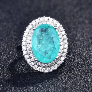 Macro view of pear-cut Paraiba tourmaline ring with double halo pavé diamonds