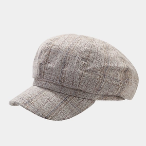 Vista detallada de la tela de tweed a cuadros grises vintage y costuras de esta gorra retro