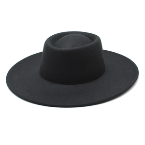 Close-up of black wool boater hat with a structured round crown and a flat brim for winter