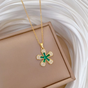 Luxurious gold flower necklace with green gemstone and white crystals on silk base