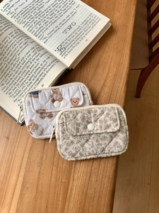 Quilted cotton mini pouches with bear and floral patterns on a wooden table surface