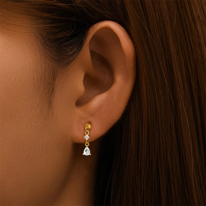Vue macro d'un clou d'oreille en argent S925 doré avec zircons ronds et en poire