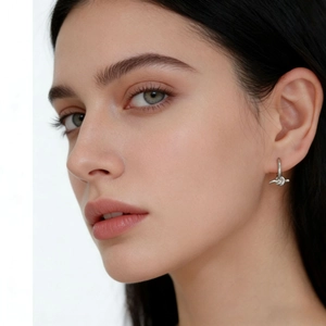 Close-up of S925 sterling silver knot hoop earrings worn by a model in soft lighting