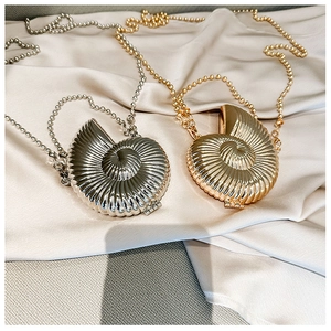Detailed view of conch shell shaped mini metal crossbody bags in gold and silver finish