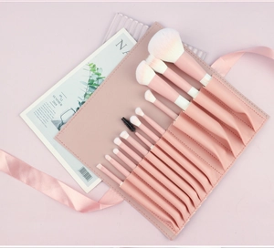 Close-up of 10-piece pink makeup brush set with gradient bristles and leather pouch