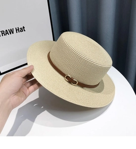 Detailed texture of straw boater hat with brown leather band and gold metal buckle
