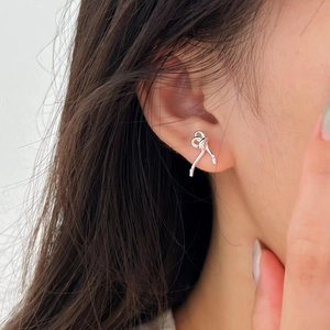 Elegant 925 sterling silver ribbon knot stud earrings with zircon stones worn by model