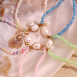 Detailed view of colorful seed beads and freshwater pearls arranged in an abalone shell