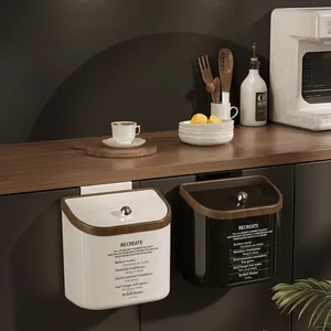 Dettaglio di pattumiere sospese con coperchio effetto legno e pomello in cristallo per cucina