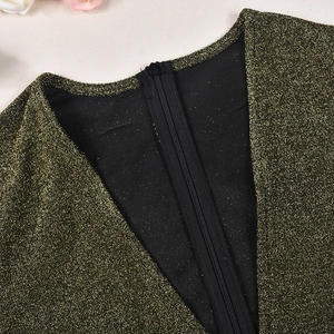 Dettaglio dello scollo a V e zip posteriore su body in paillettes dorate elasticizzate