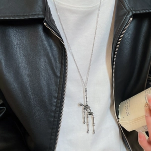 Silver skull pendant necklace with tassels styled on a model in a black leather jacket