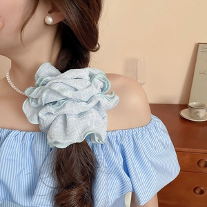 Detail showing the light blue ruched fabric texture of the oversized scrunchie