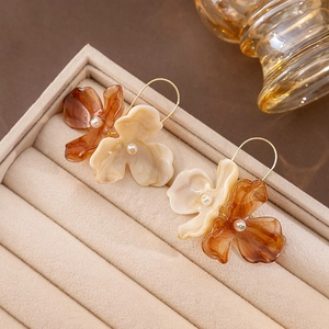 Vintage floral pearl earrings in amber brown and cream white on a velvet jewelry box