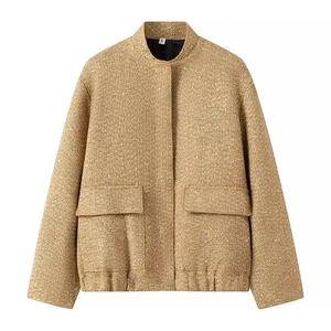 Detail of champagne gold tweed jacket with sequins, standing collar, and woven texture