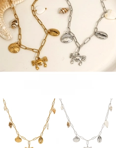 Détail de pendentifs crabe et coquillage en acier inoxydable doré et argenté