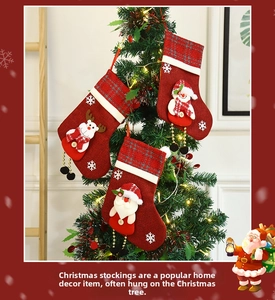 Close-up of festive Christmas stockings hanging on a tree with reindeer and snowman patterns