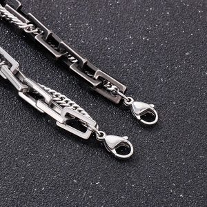 Close-up of double-layer silver and black Cuban chains with secure lobster clasps