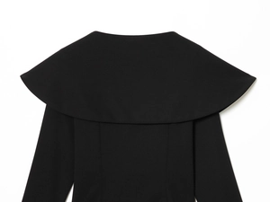 Detail of the high-quality woven fabric and elegant neckline on the black long-sleeve top