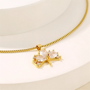 Golden clover pendant necklace with zircon on a white stand, minimalist box chain style