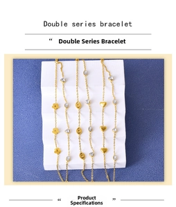Detailed view of double-layer gold bracelets with flower, evil eye, and heart charms