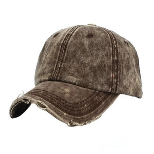 Detailed close-up of brown distressed washed cotton baseball cap with torn brim details