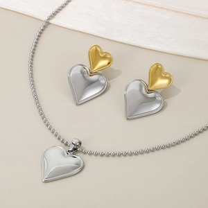 Detailed view of bicolor heart-shaped stud earrings and matching pendant necklace