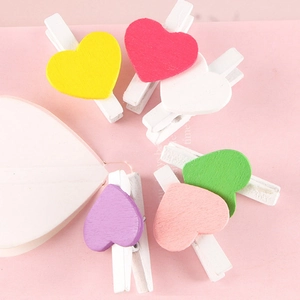 Colorful mini wooden heart clips set on pink background for Valentine decorations